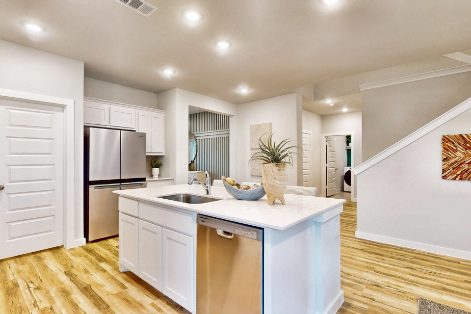 A kitchen with white cabinets.