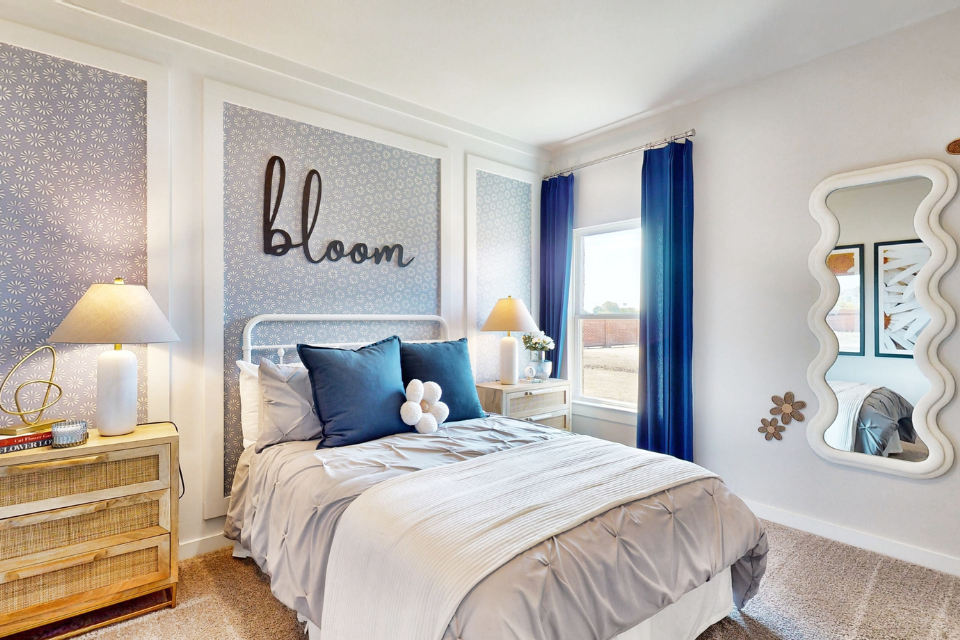 A bedroom with a bed and blue curtains.
