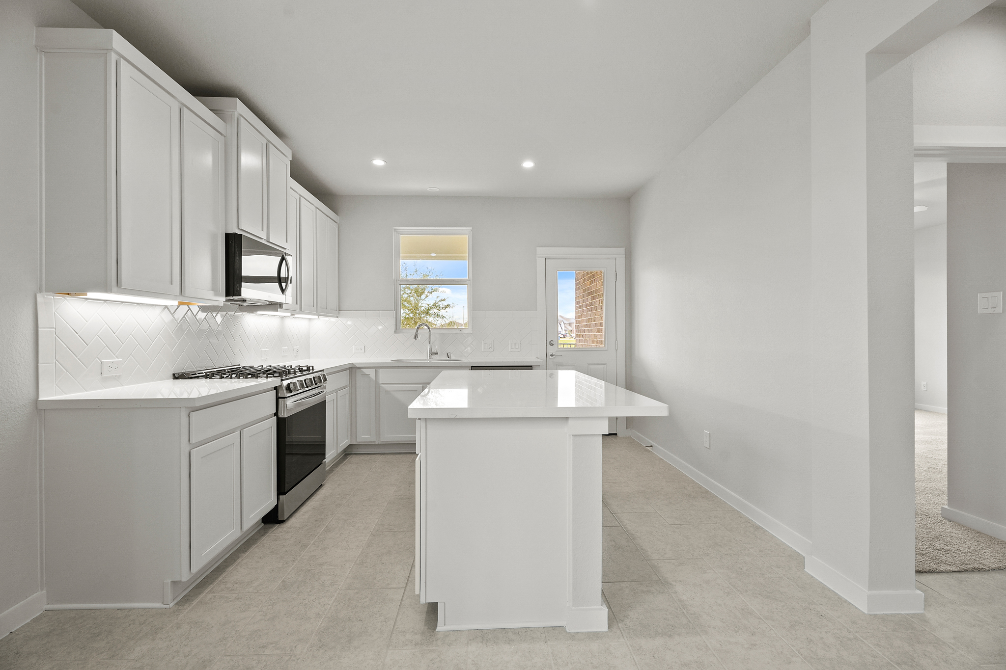 A kitchen with white cabinets.