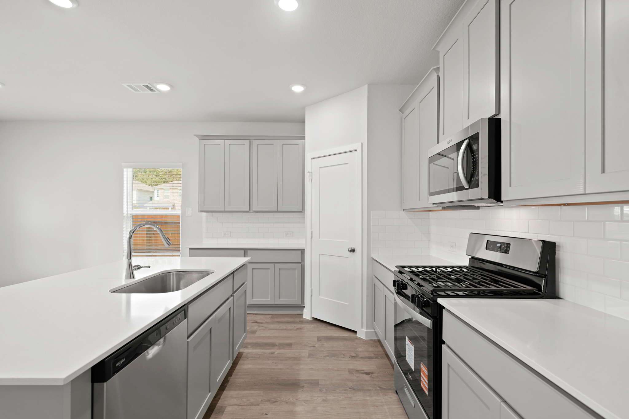 A kitchen with white cabinets.