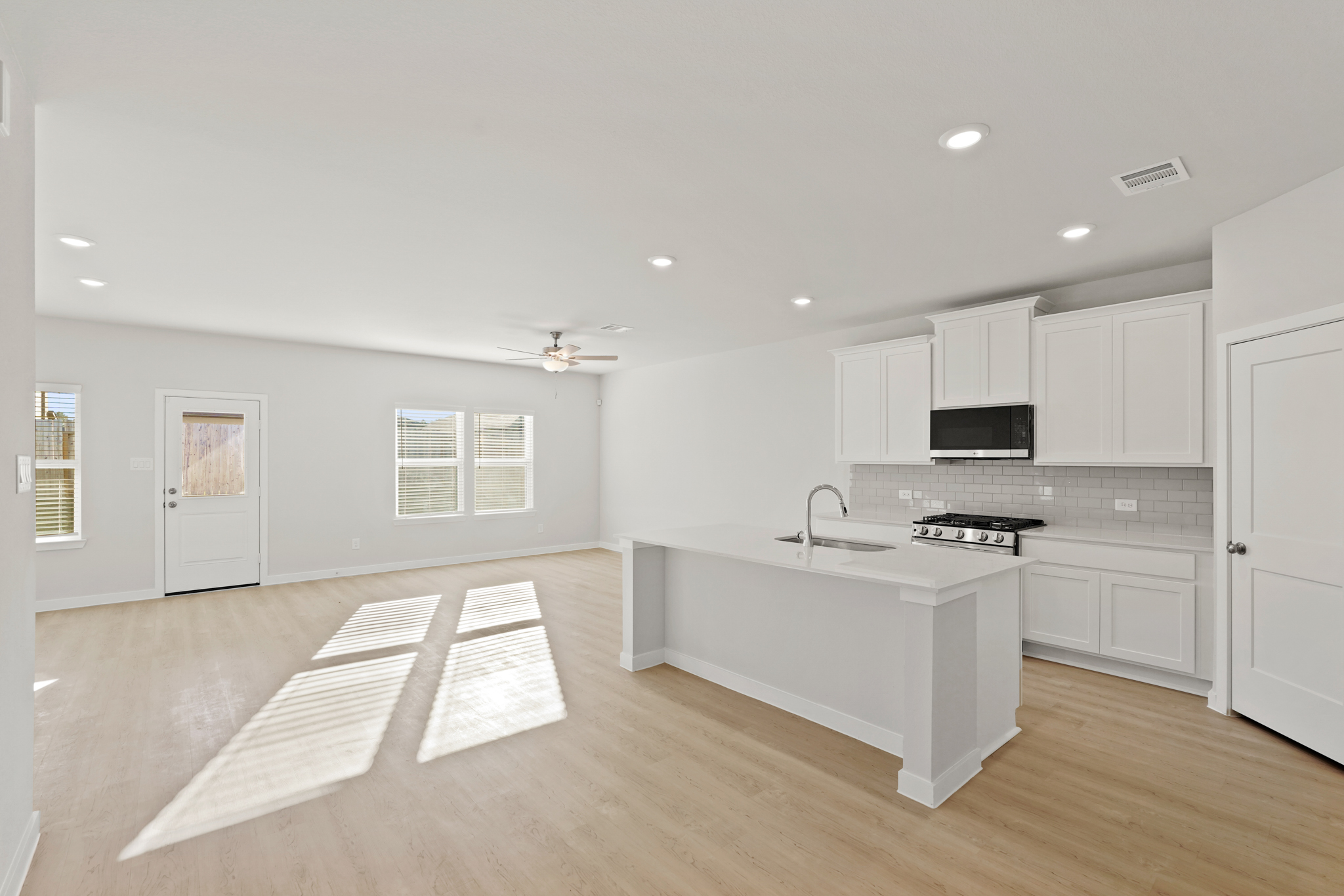 A kitchen with white cabinets.