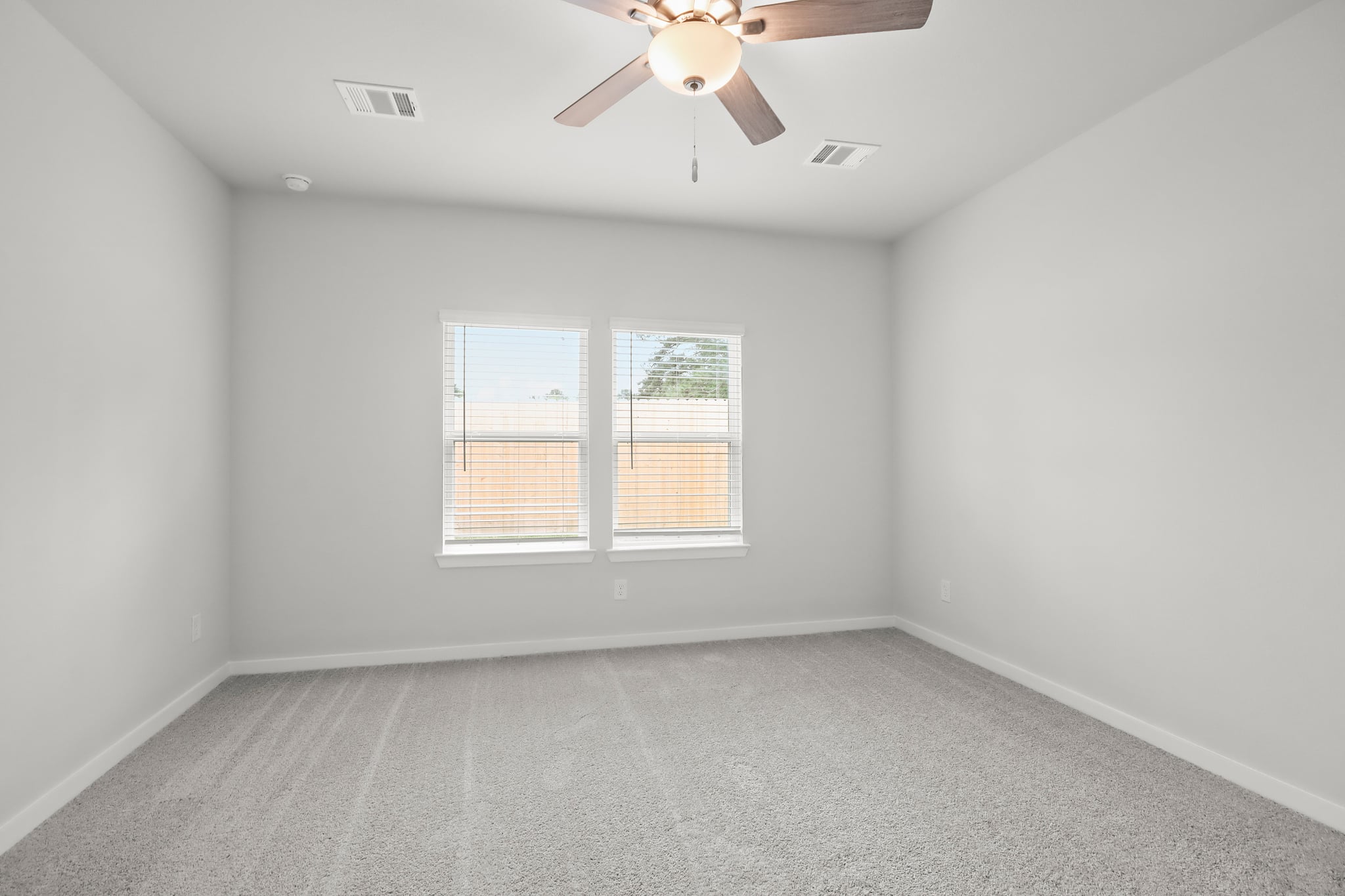 A room with a ceiling fan and a window.