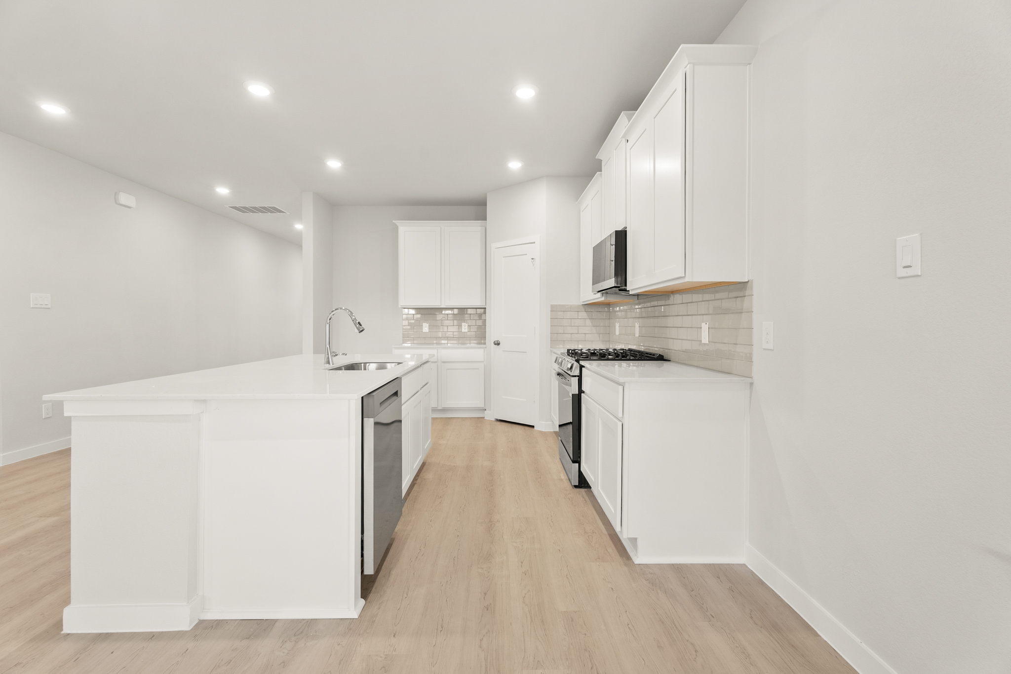 A kitchen with white cabinets.