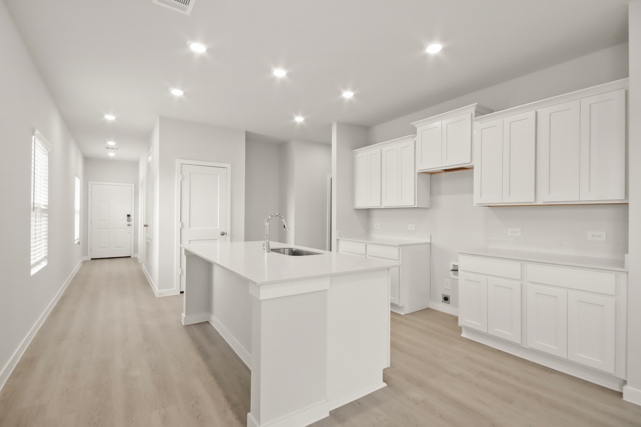 A kitchen with white cabinets.