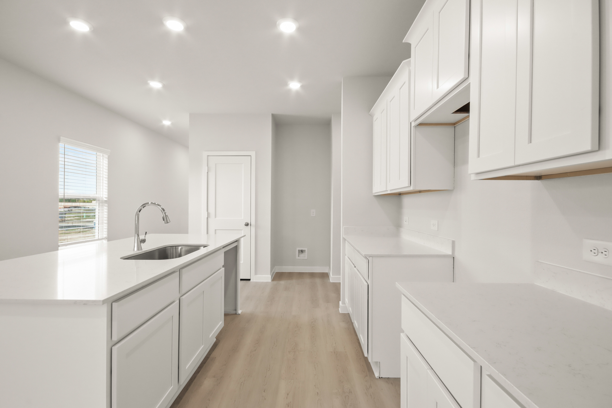 A kitchen with white cabinets.