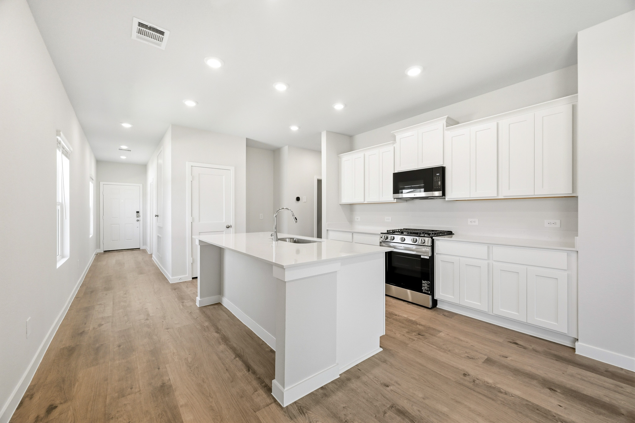 A kitchen with white cabinets.