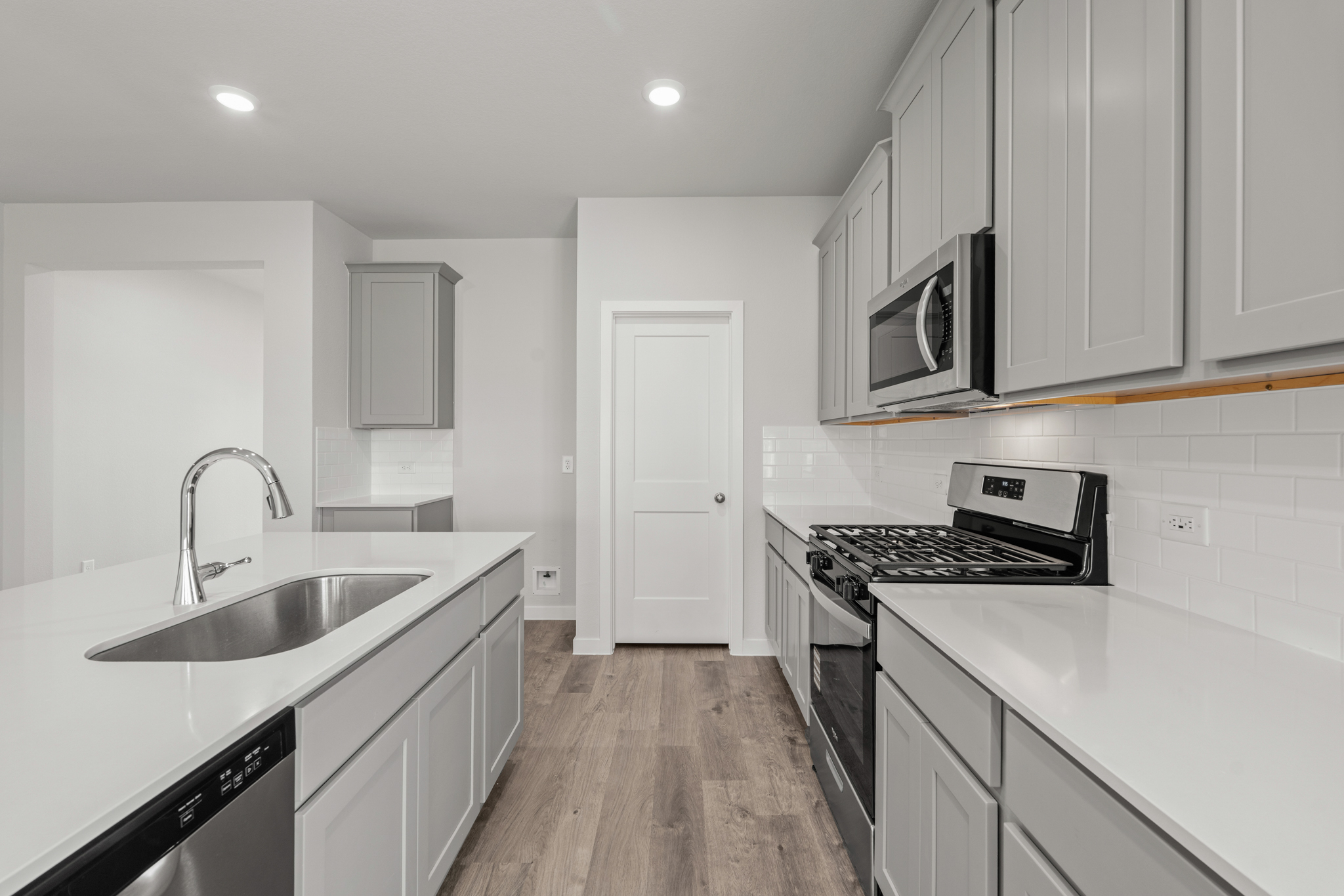 A kitchen with white cabinets.