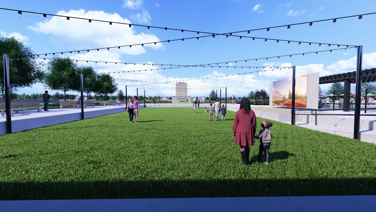 A person and a child walking on a grass field.