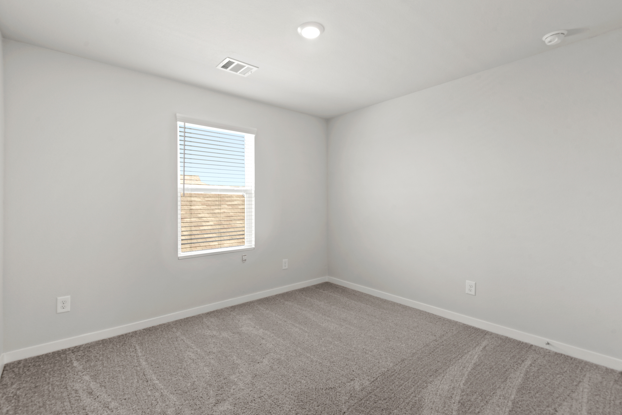 A room with a window and a carpet.