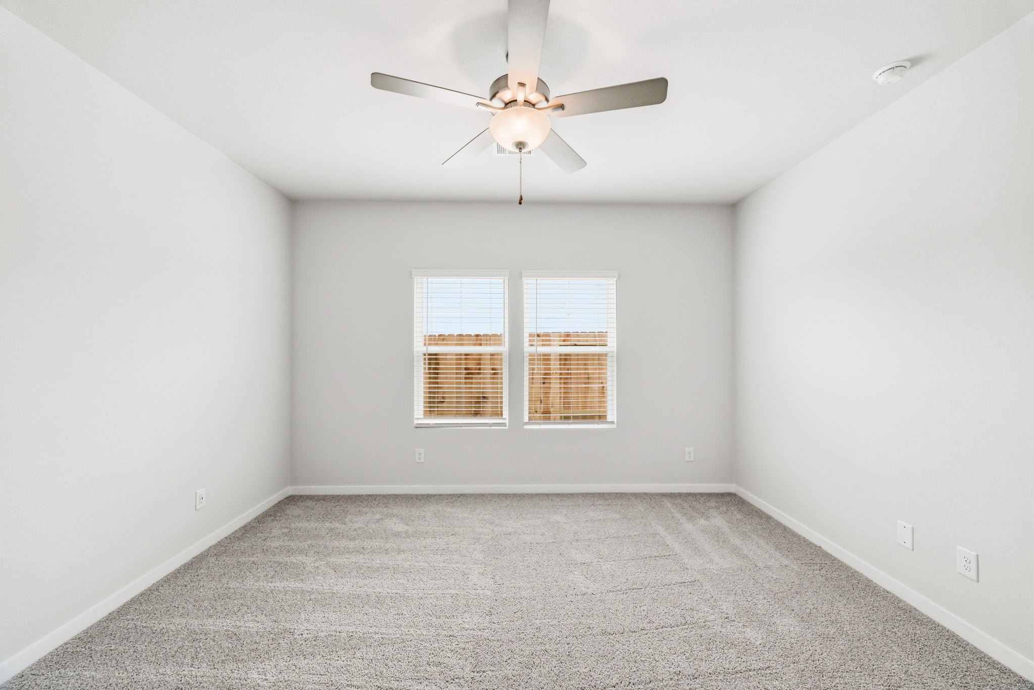 A room with a ceiling fan and a window.