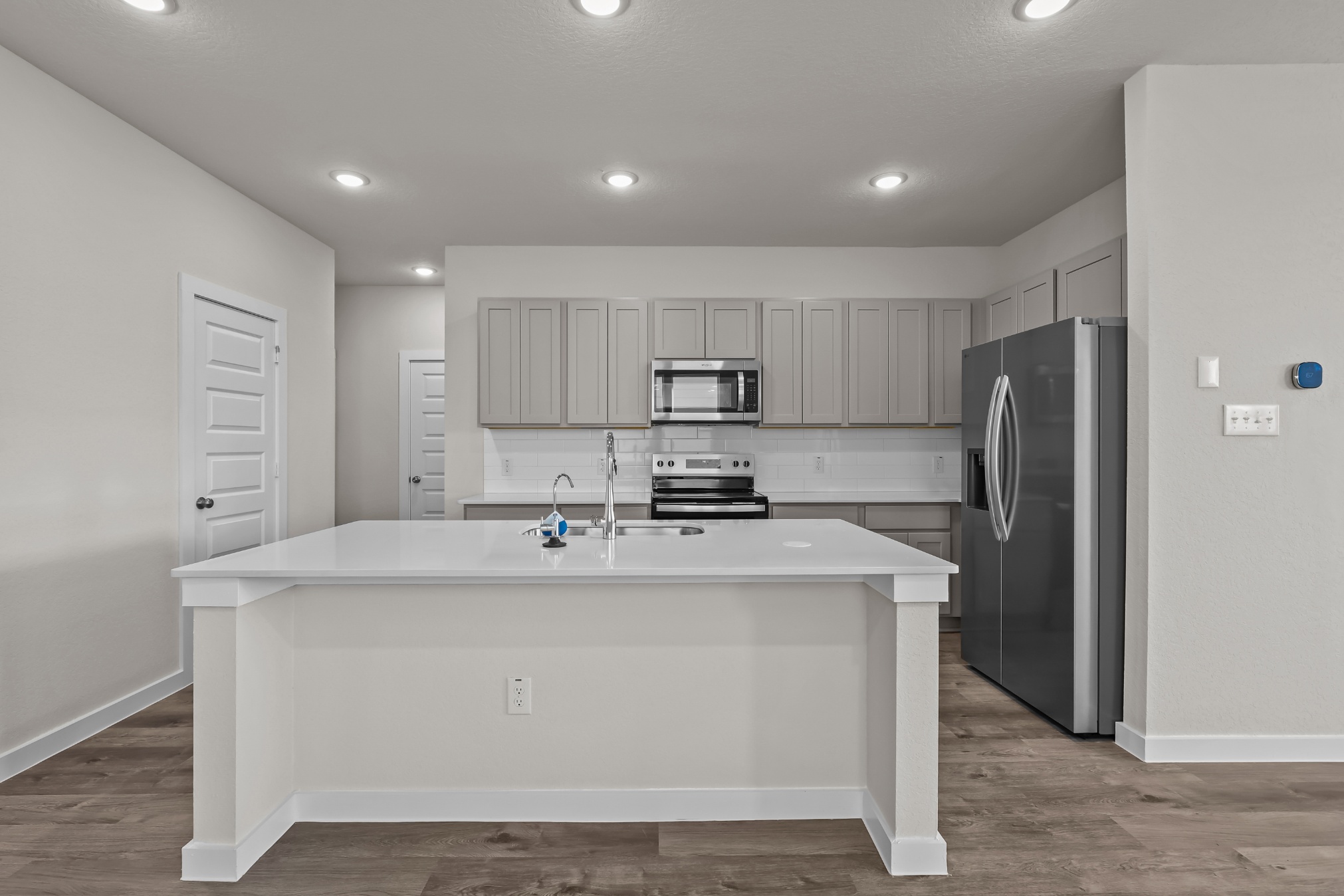 A kitchen with white cabinets.