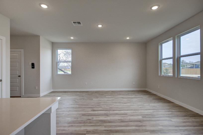 A room with a wood floor and windows.