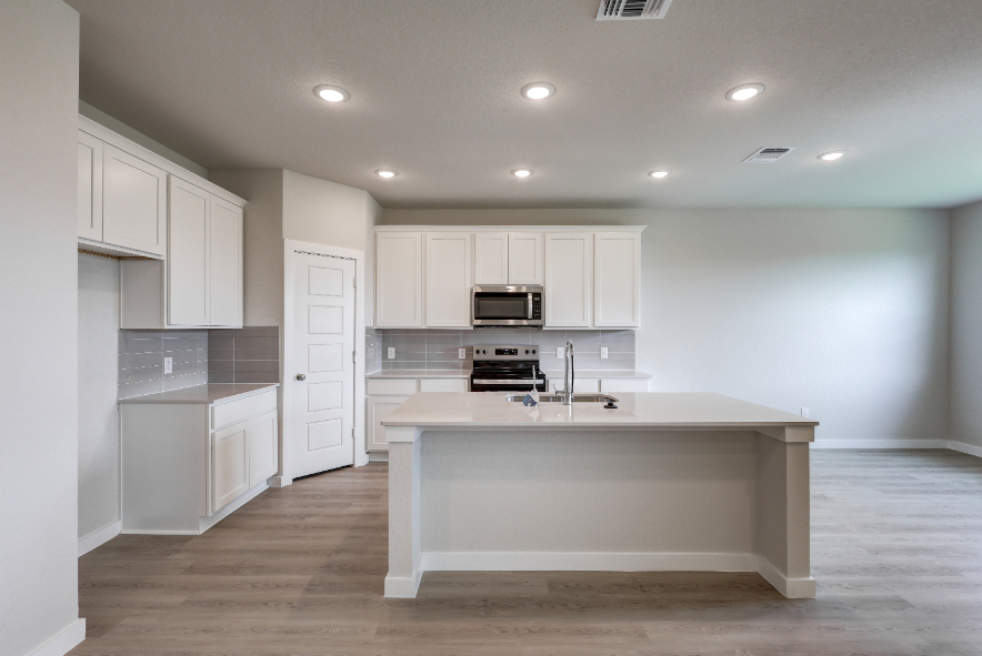 A kitchen with white cabinets.