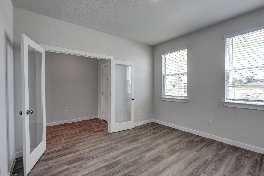 A room with a wood floor and white walls.