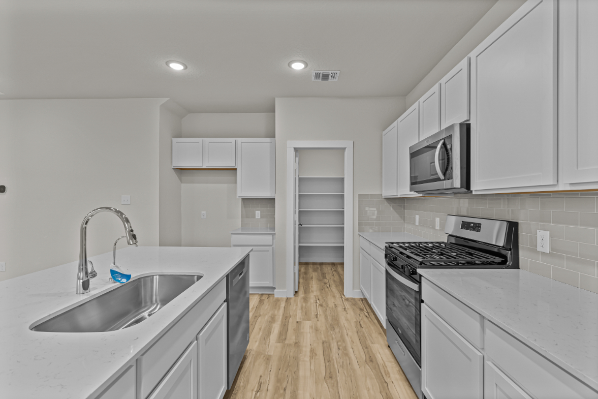 A kitchen with white cabinets.
