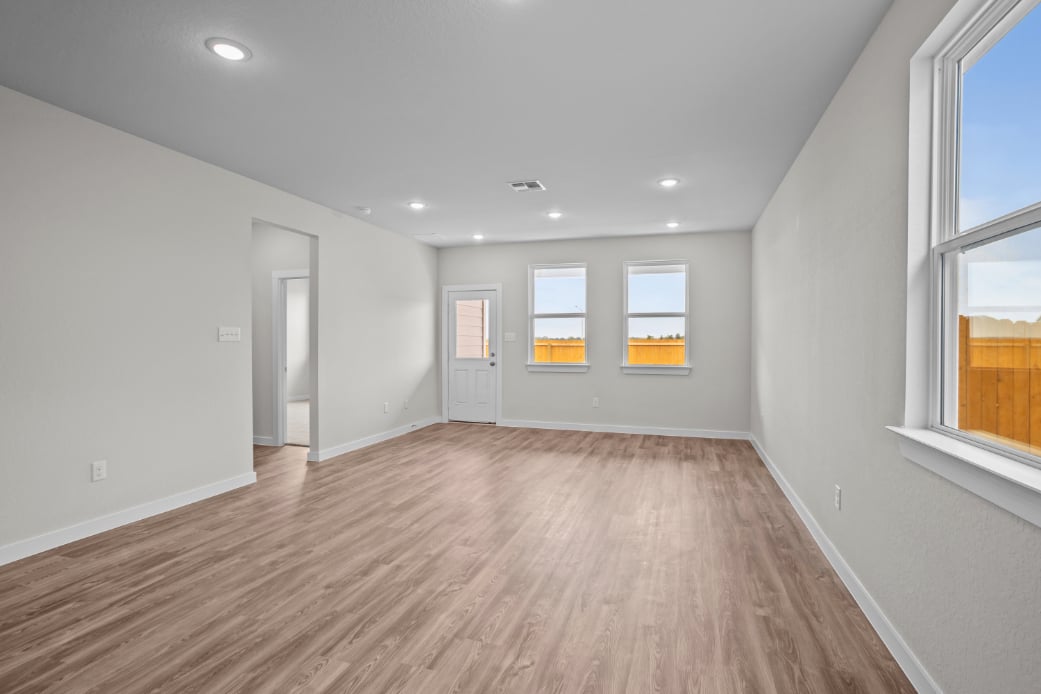 A room with a wood floor and windows.
