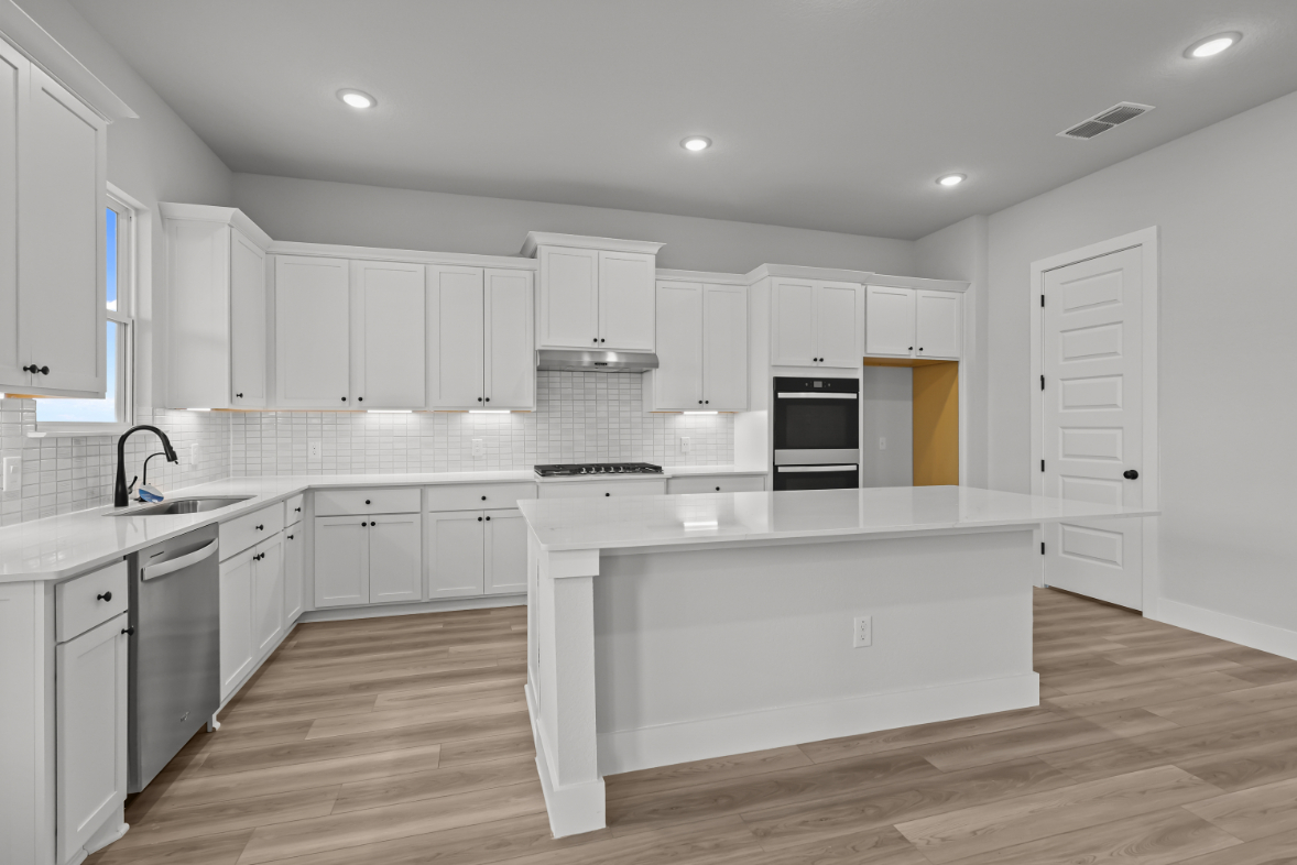 A kitchen with white cabinets.