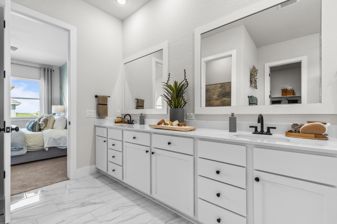A bathroom with white cabinets.