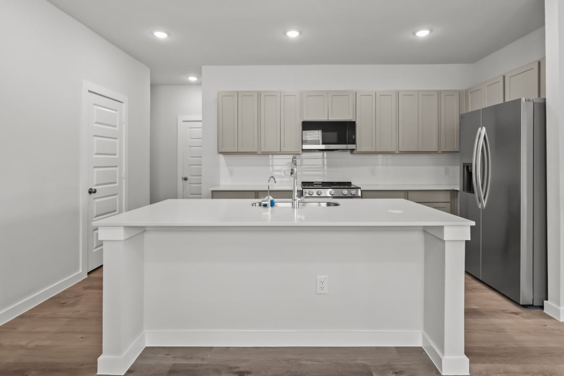 A kitchen with white cabinets.