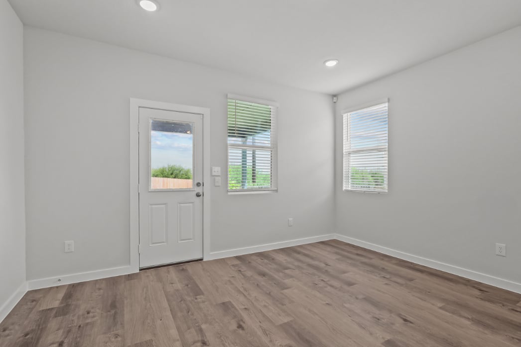 A room with a wood floor and a white door with windows.