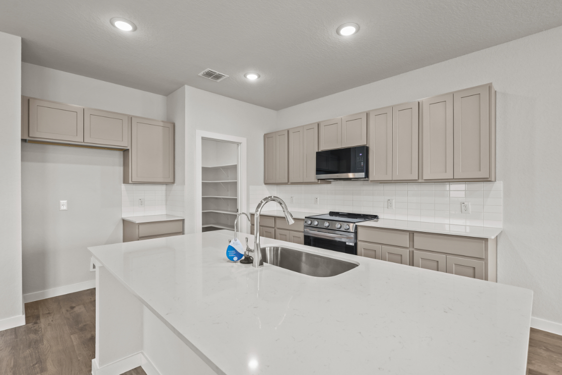 A kitchen with white cabinets.