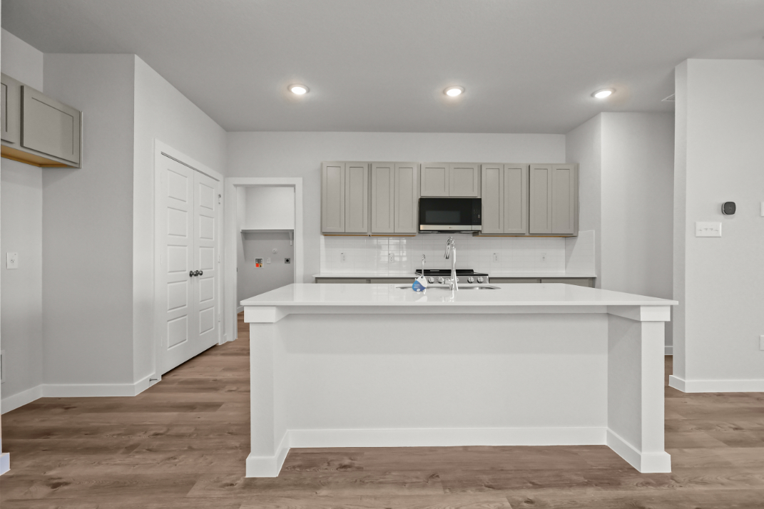 A kitchen with white cabinets.