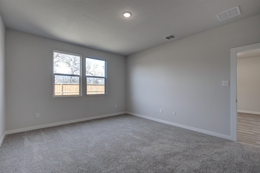 A room with a window and a carpet.