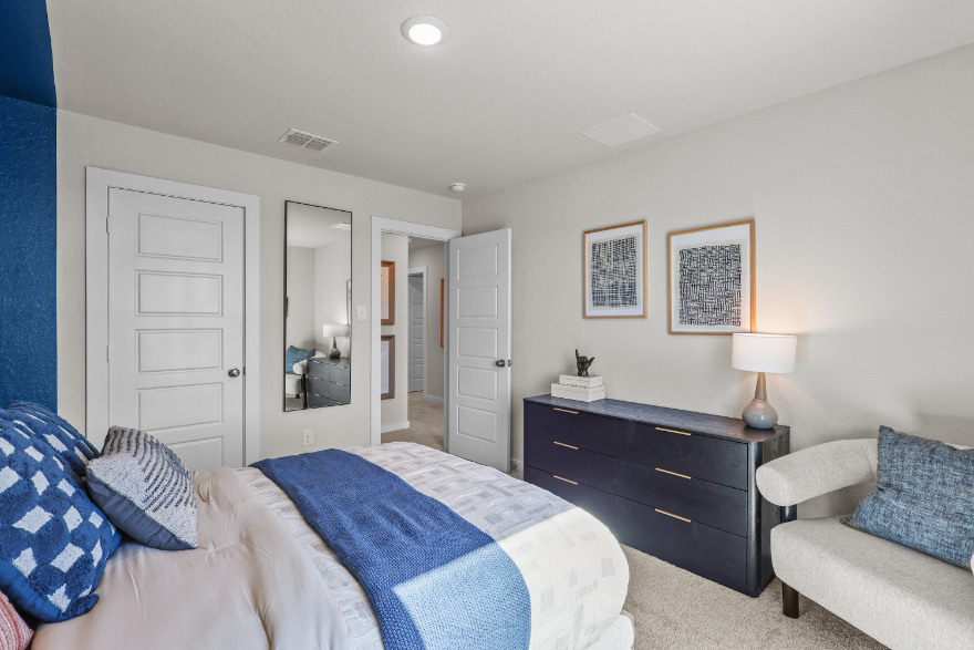 A bedroom with a bed and a dresser.