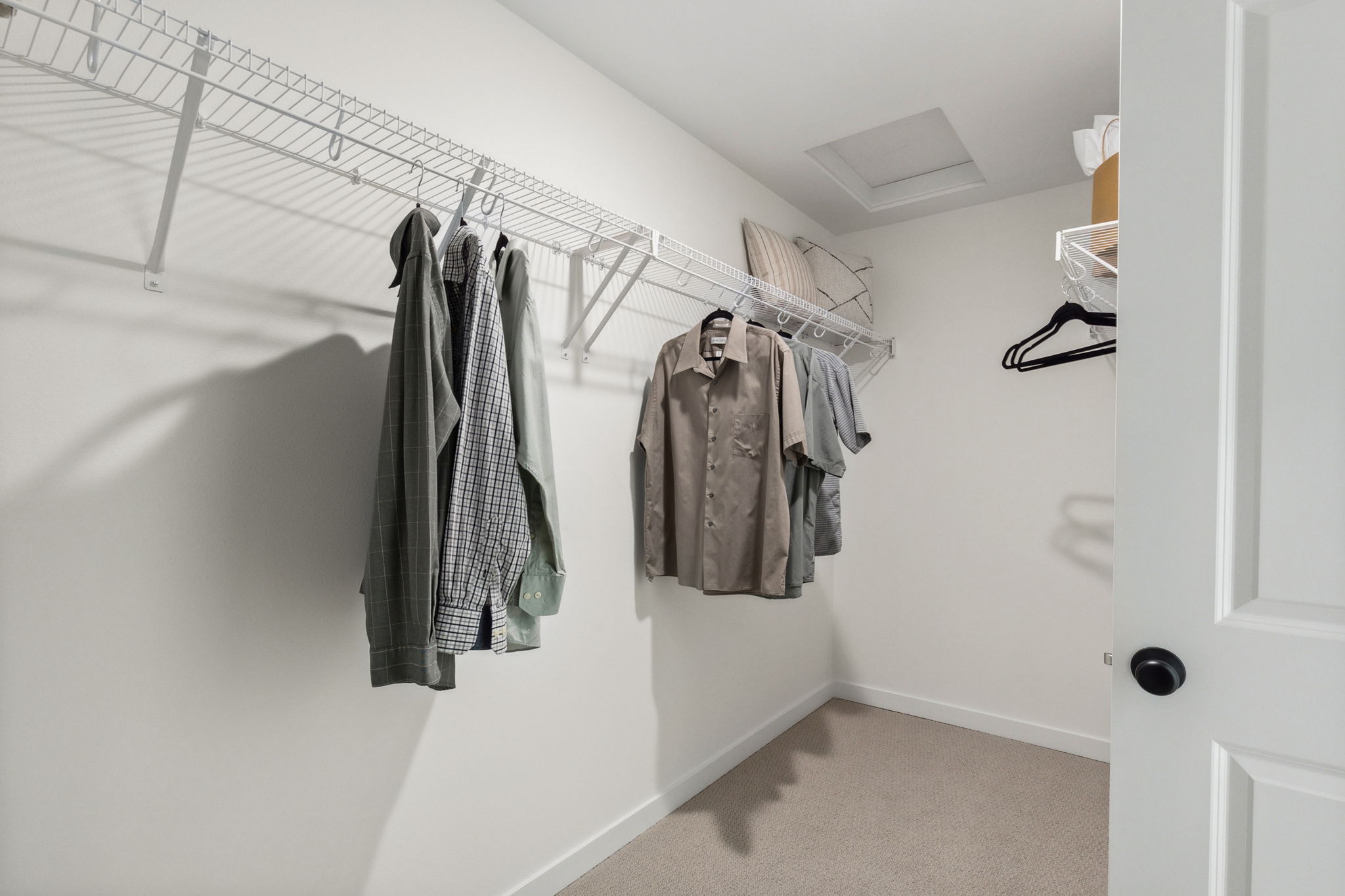 A room with a row of clothes on a rack.