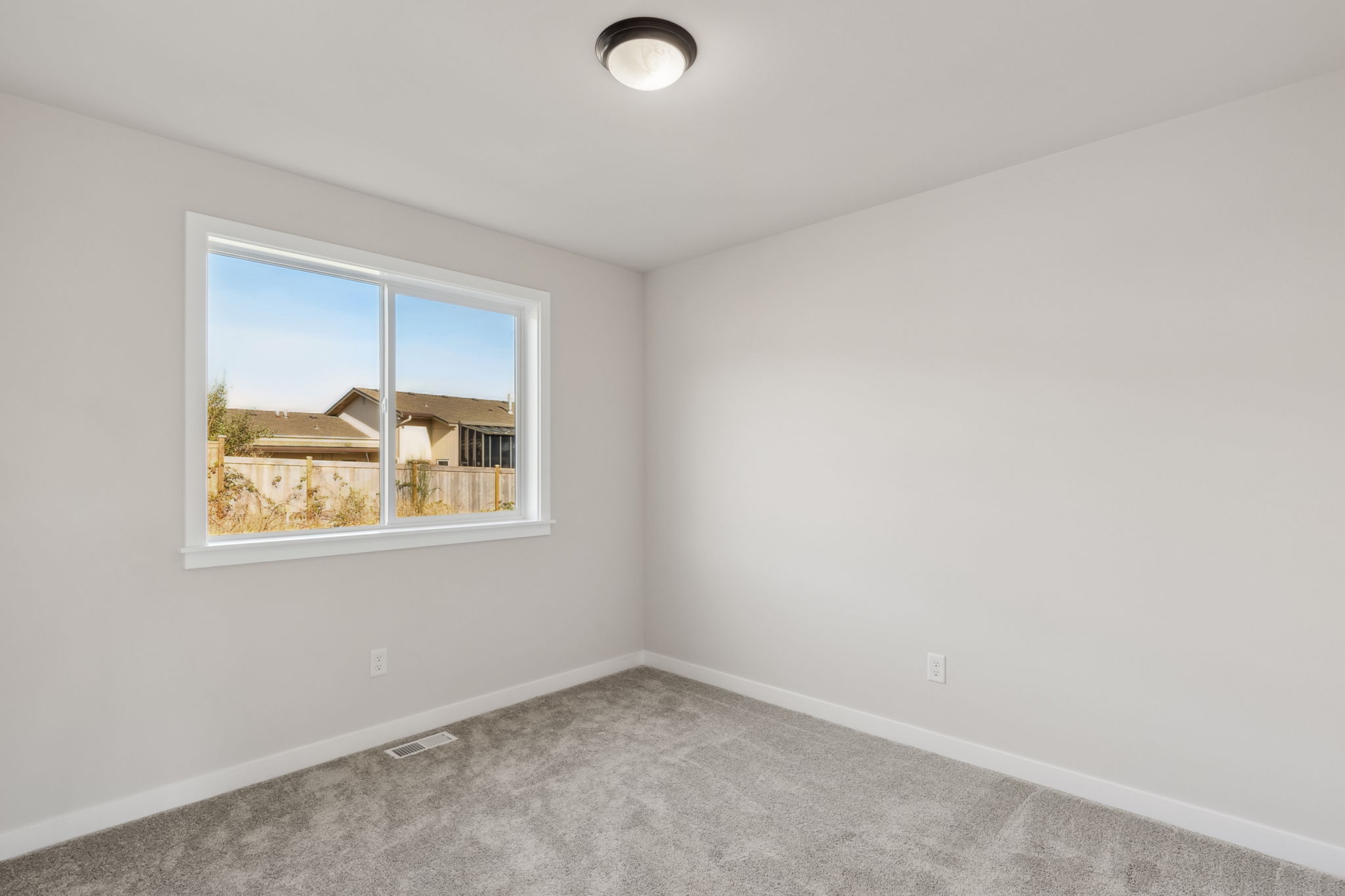 A room with a window and a carpet.