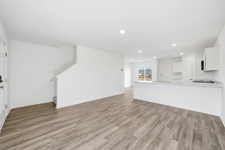 A room with white walls and wood floors.