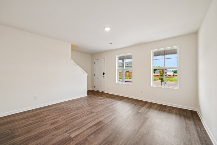A room with a wood floor and a wood floor with a window.
