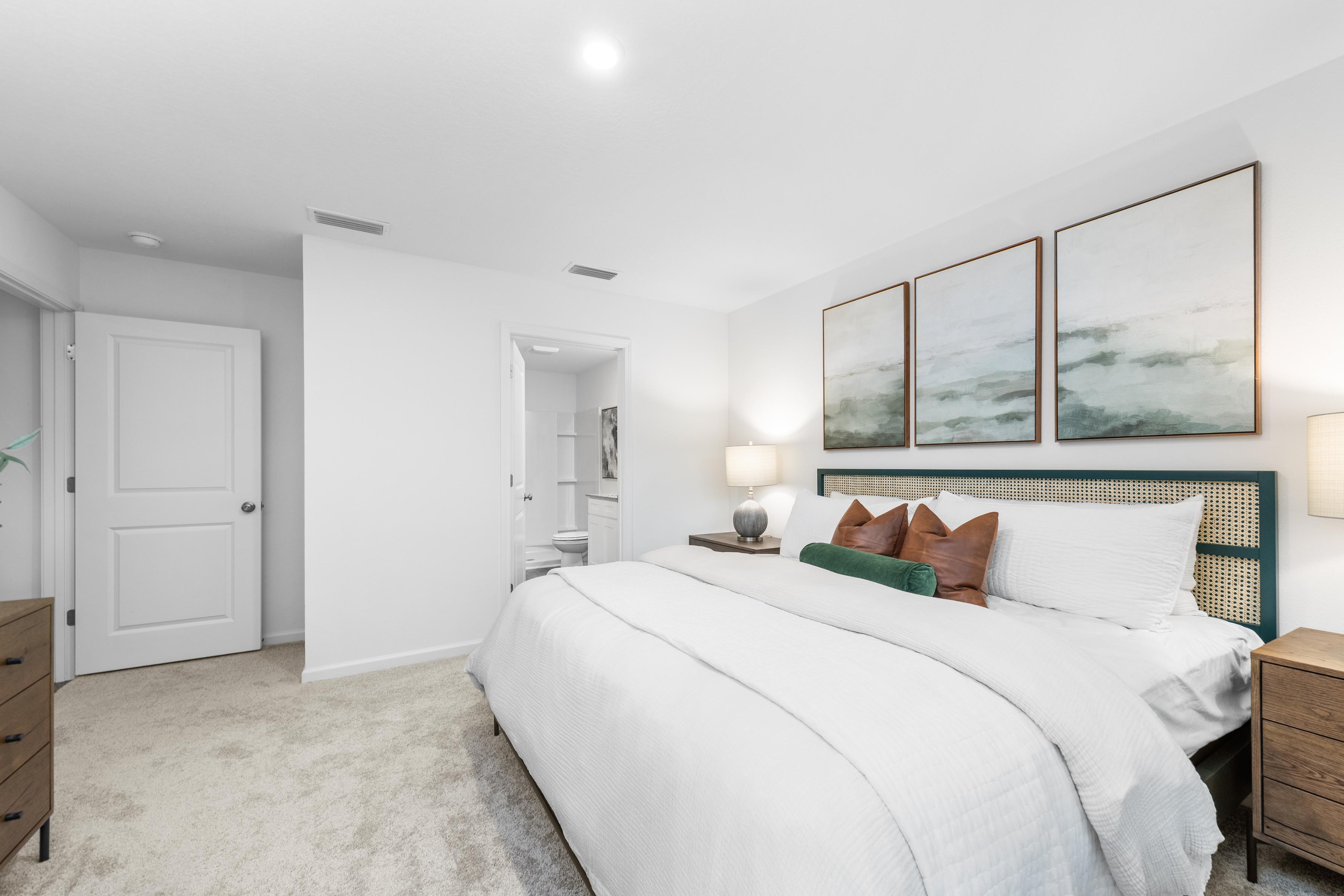 A bedroom with a bed and a lamp.