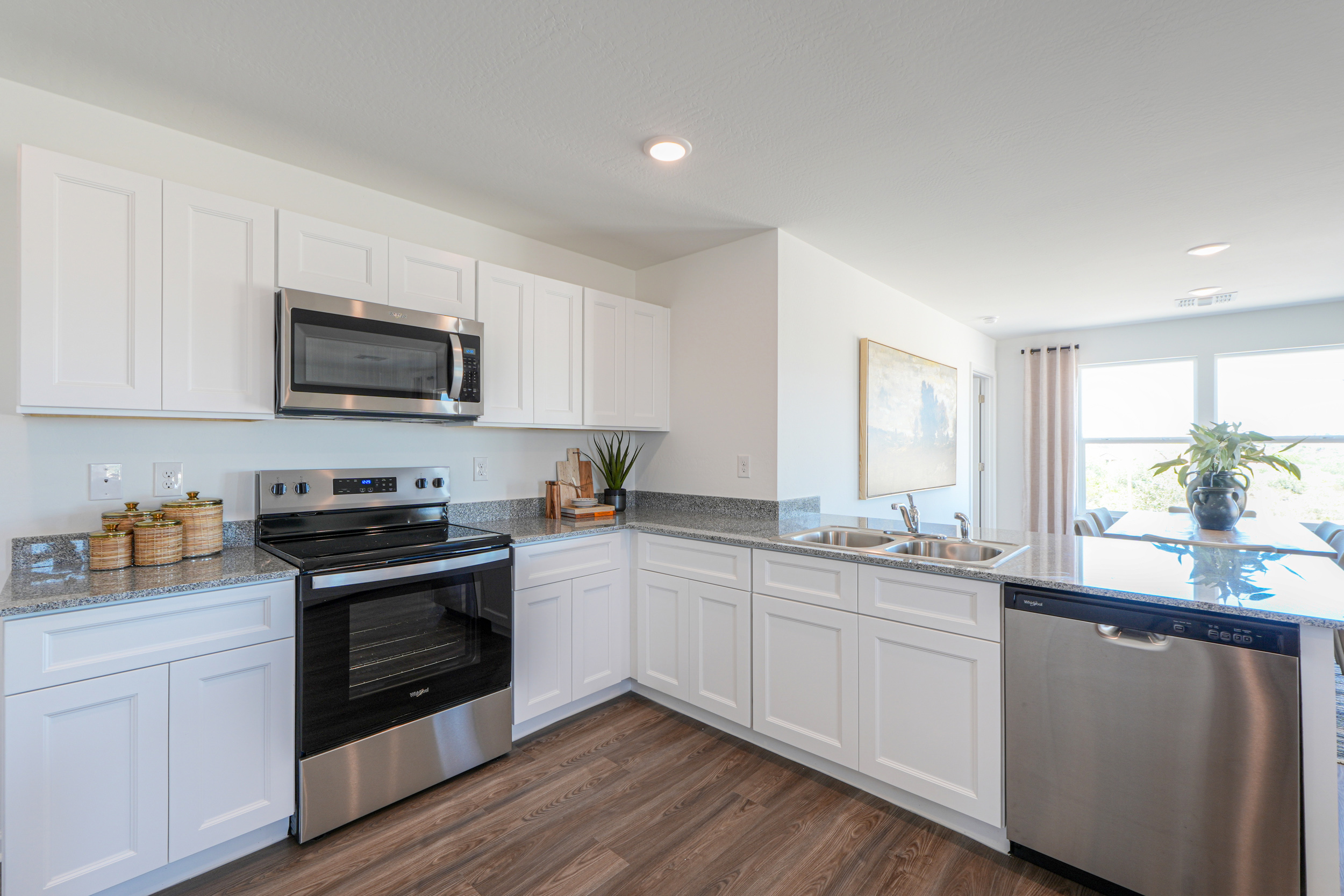 A kitchen with white cabinets.