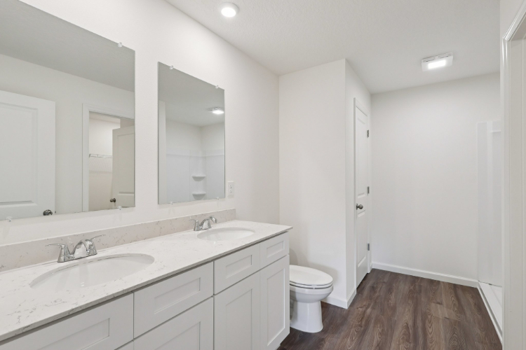A bathroom with a toilet sink and mirror.
