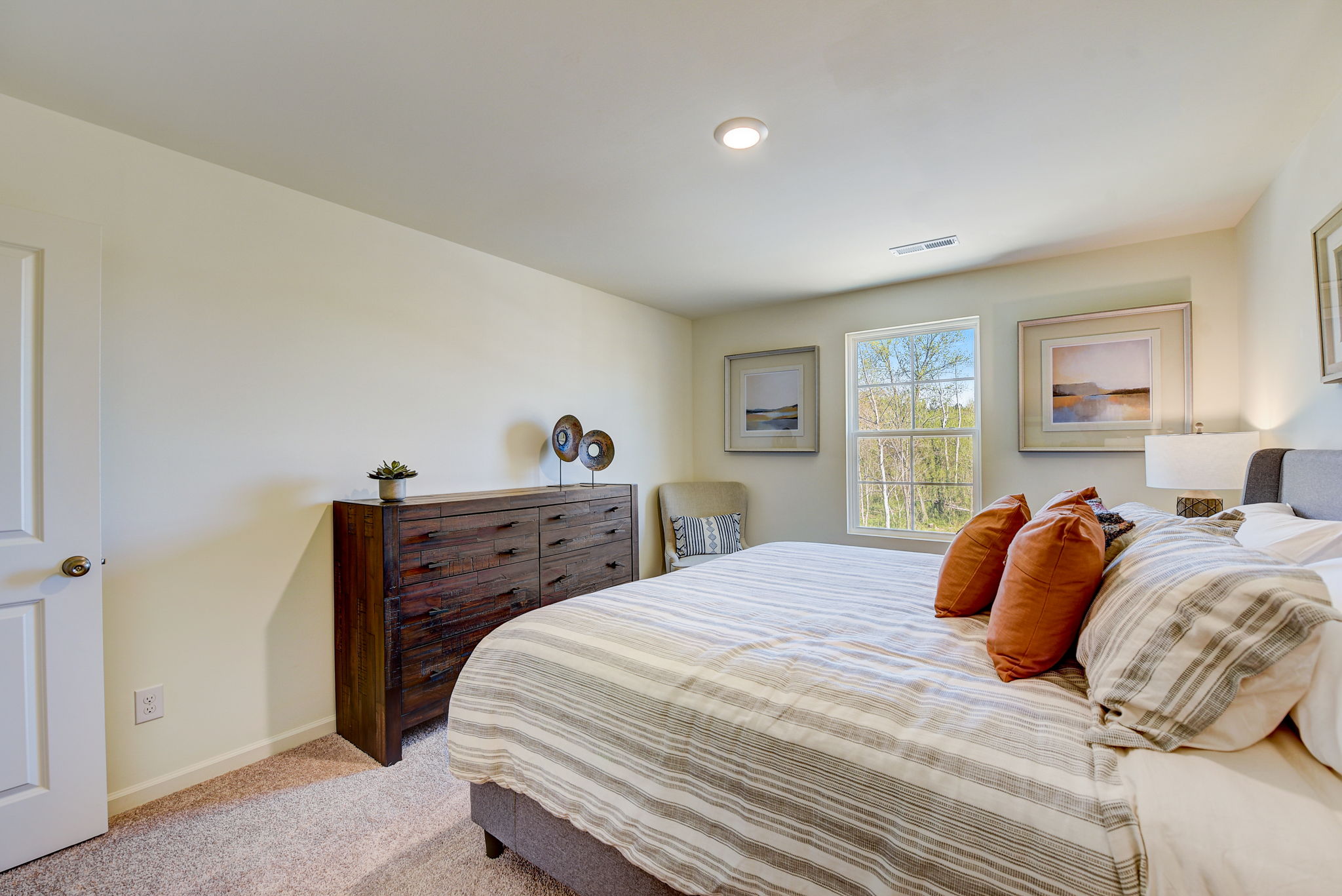 A bedroom with a bed and a chair.