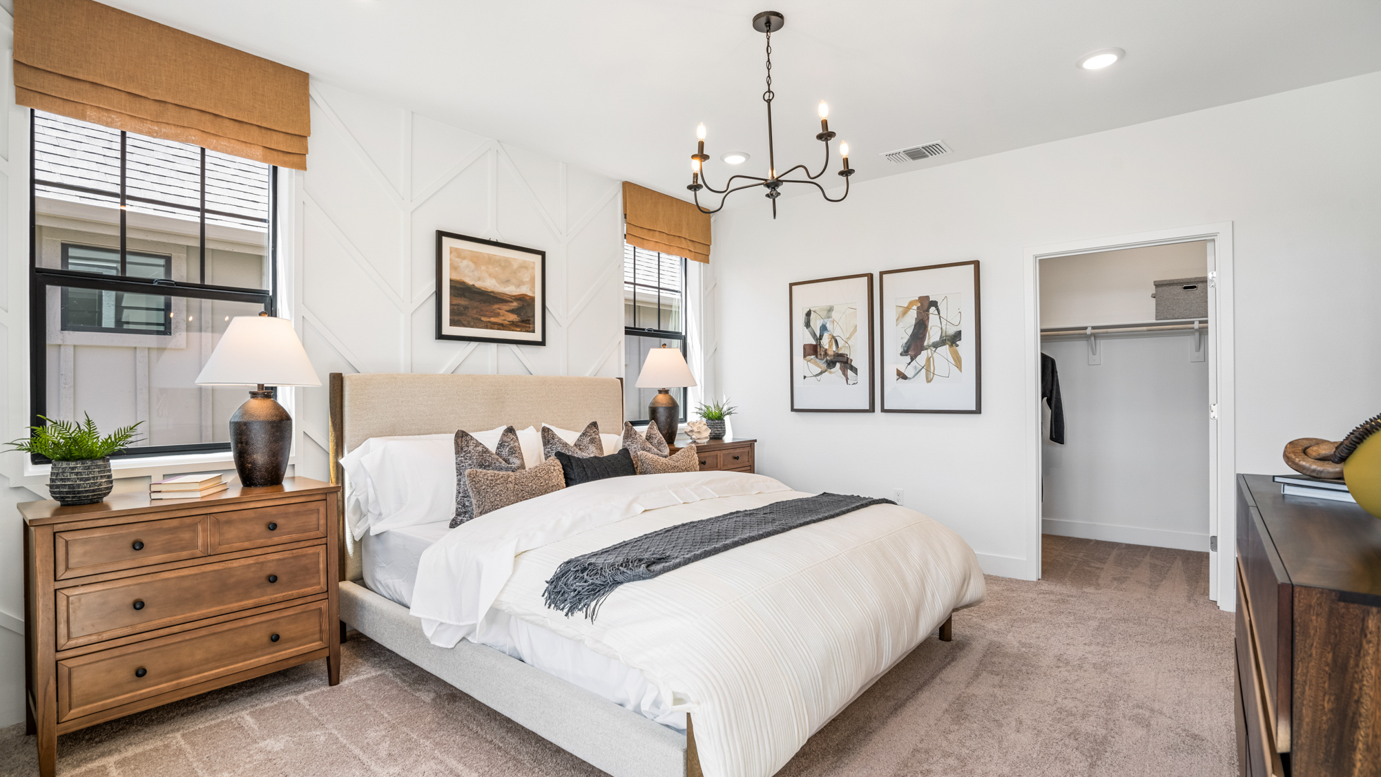 A bedroom with a bed and lamps.